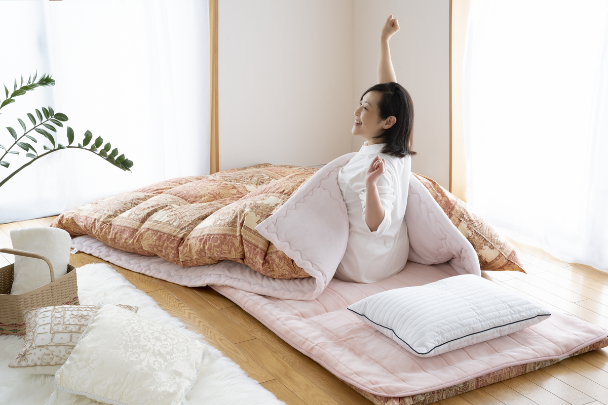 敷布団の上で気持ちよく目覚める女性
